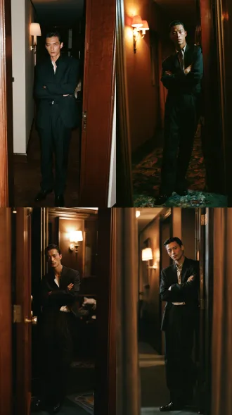 a chinese man in his mid twenties, east asian features, lean slender build, sleek composed arrogant look, hair slicked back with pomade, dark slim cut suit with shirt open two buttons, polished leather shoes, arms folded across chest, medium shot three quarter view, hotel corridor doorway, warm wall lamp light, full color photograph, 35mm film still