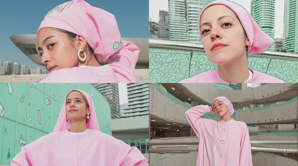 中等特写肖像镜头，30岁戴头巾的女性，摆出有创意的优雅姿势，自信且鼓舞人心的表情，粉色头巾自然随风飘动，捕捉到空中的柔和动态，穿着搭配的粉色简约连衣裙，有逼真的布料褶皱，现代都市背景，当代建筑柔和模糊，电影般柔和的漫射日光，专业时尚广告照明，用全画幅相机和85mm镜头拍摄，浅景深，超逼真的皮肤纹理带自然毛孔，锐利的眼睛有干净的反光点，和谐的粉色调色板，简约的高级时尚构图