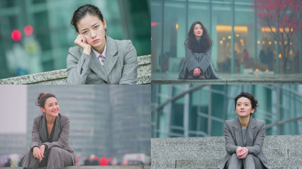 中国女白领坐在办公楼前石阶上，表情若有所思，穿着干练职业装，背景是虚化的现代玻璃幕墙大楼，黄昏柔和光线，浅景深，环境肖像，冷色调中带有暖光，氛围宁静而略带疲惫。