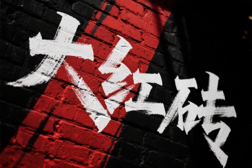 黑色背景上抽象倾斜红砖刻“大红砖”毛体字，凹刻白灰，占半画面，摇滚暗黑风，低角度，侧逆光，粗旷笔触，力量感。 